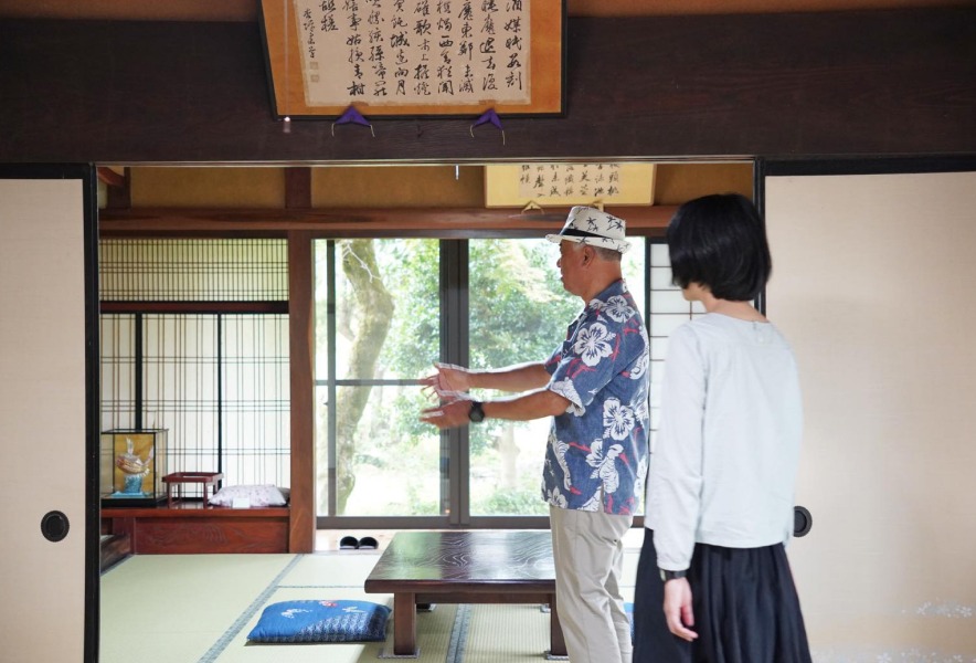 窓の外を指して周辺を案内する前田さん